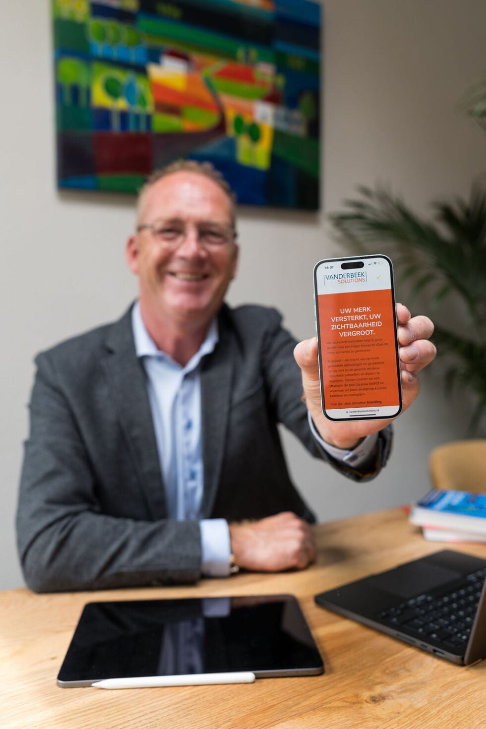 Chris van der Beek laat een website zien op zijn telefoon